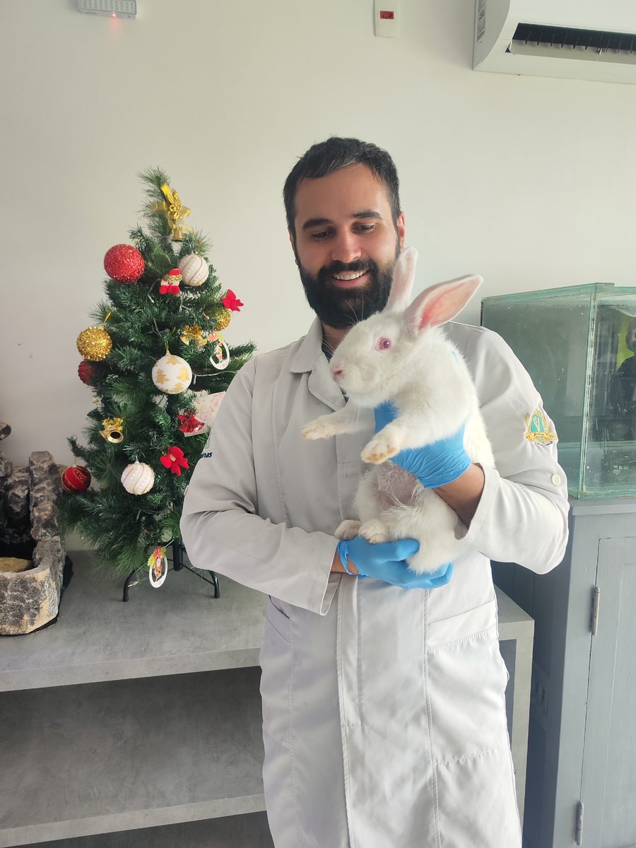 Dr. Thiago Freitas Ferreira com paciente coelho em atendimento