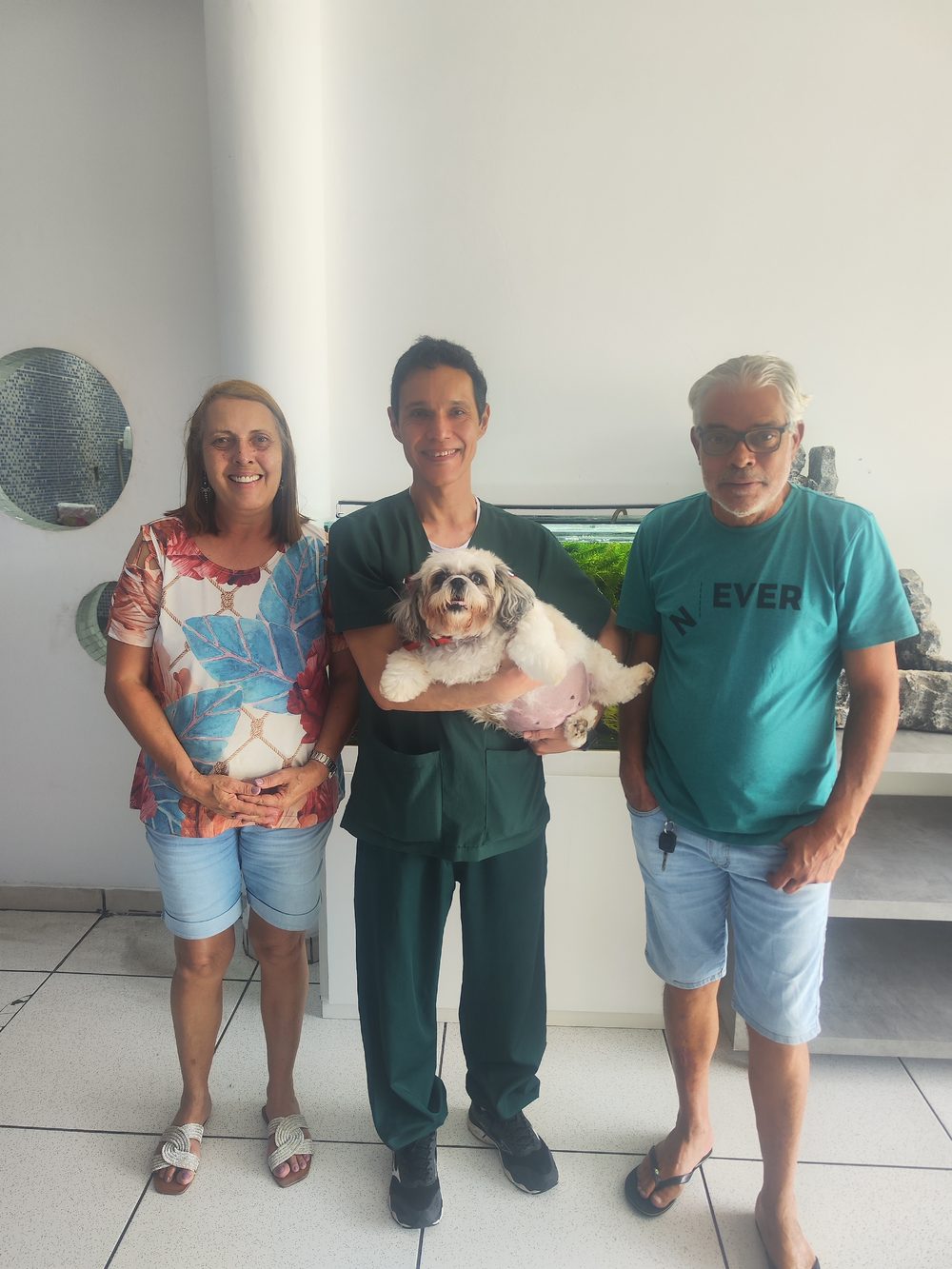 Dr. Luciano em atendimento com paciente cachorro ao lado dos tutores